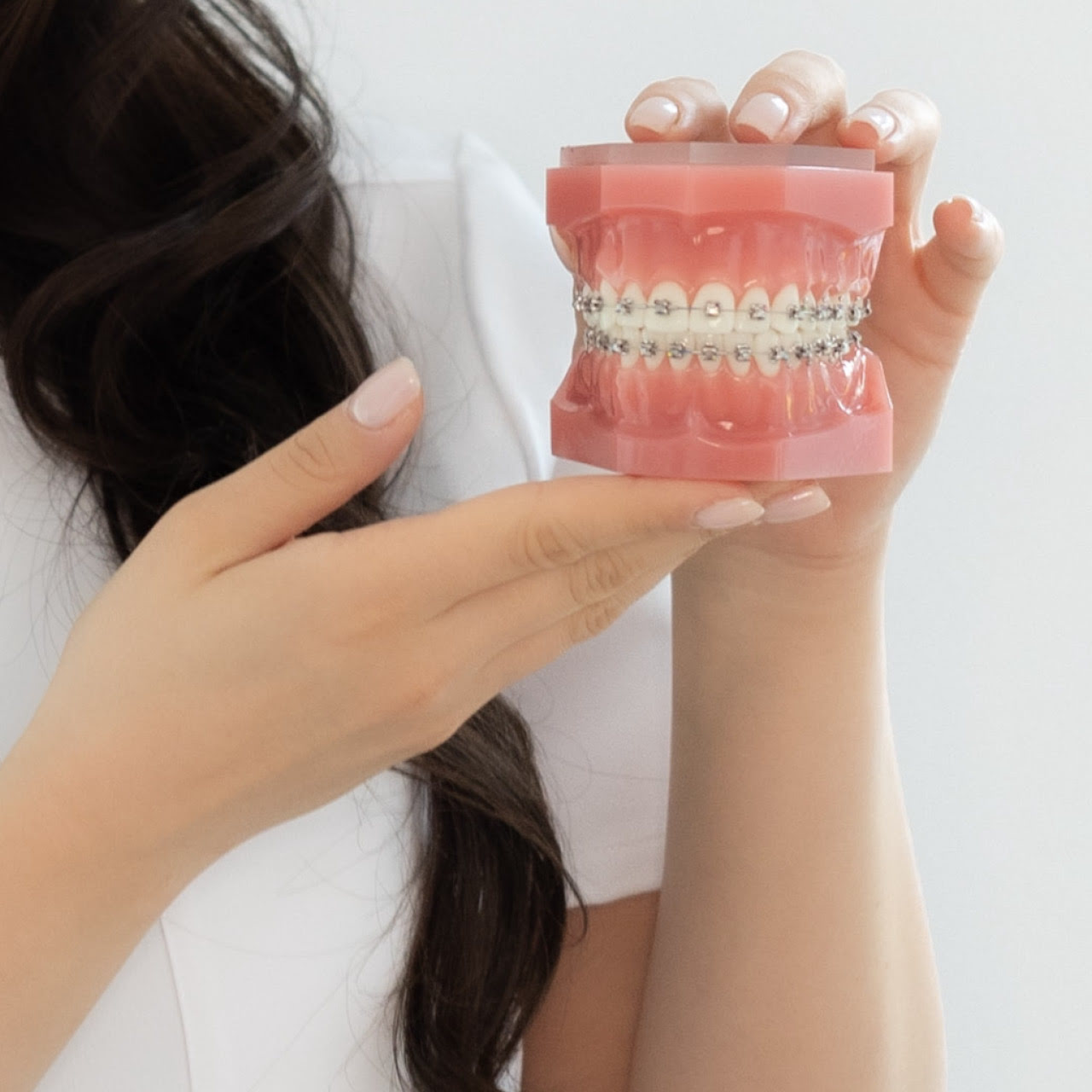 Dr. Tara Rezwan zeigt ein Gebiss-Modell mit Zahnspange.